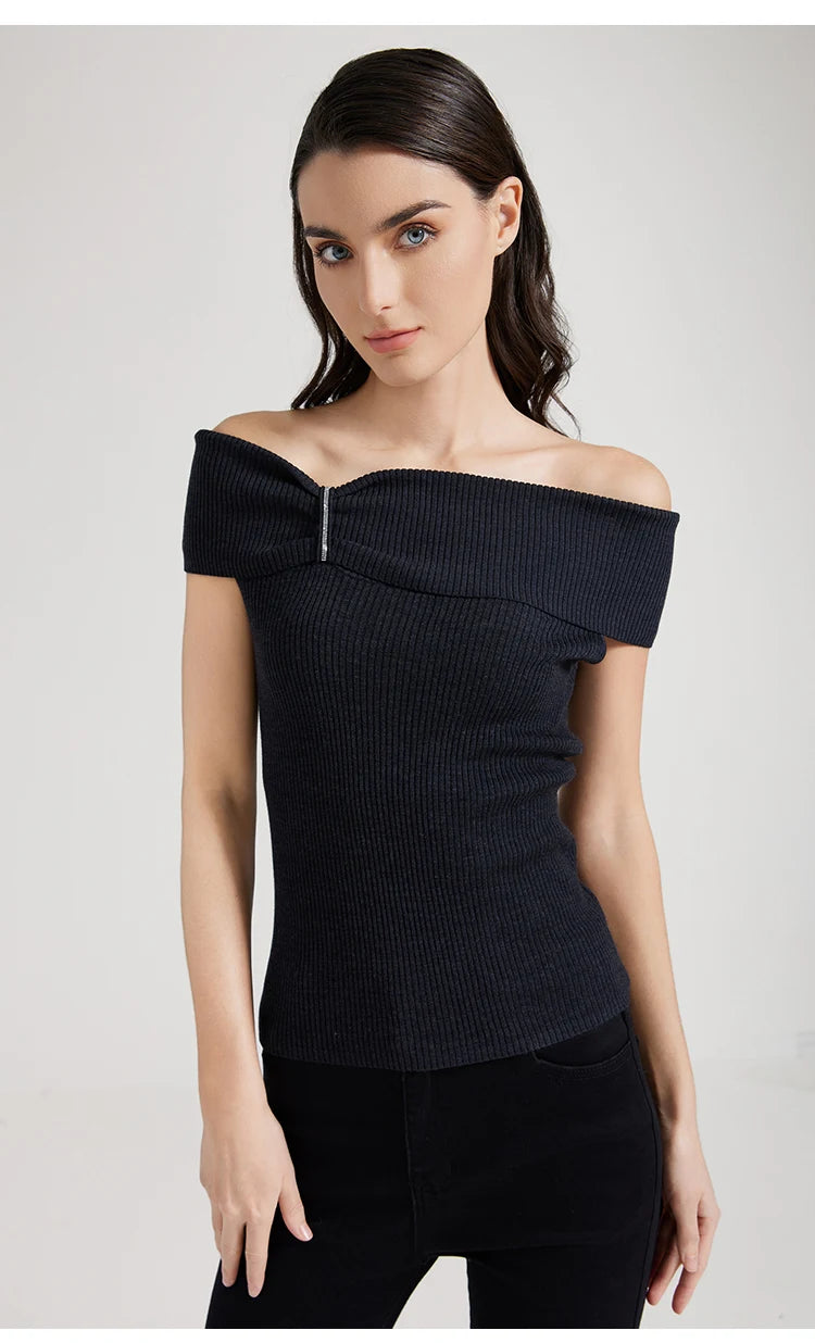 Model in Black Pearl off-the-shoulder top, both hands resting on the hips. From Borcelleclothes.