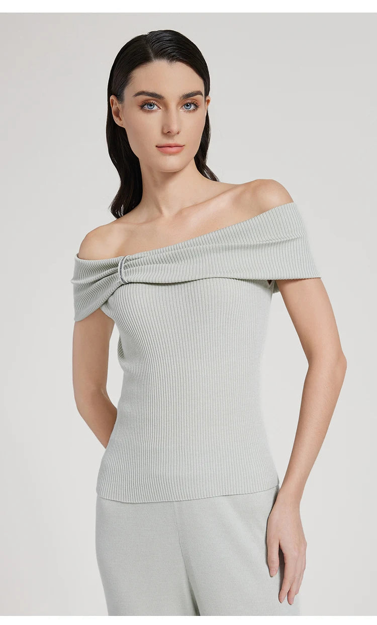 Model wearing the off-the-shoulder wool-silk top in Geyser, one hand resting on the hip. From Borcelleclothes.