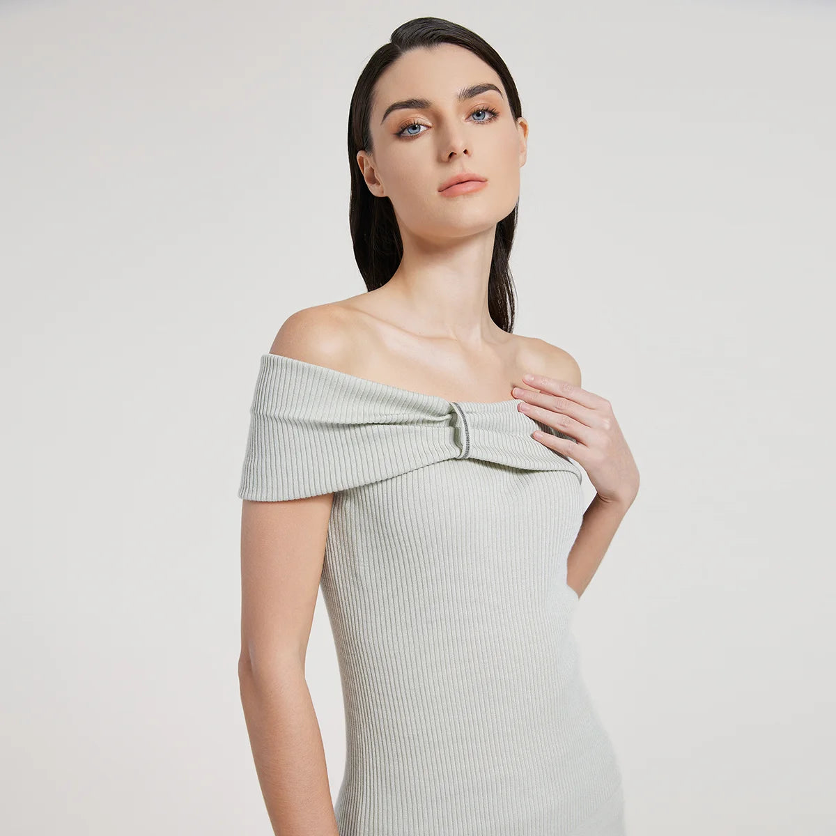 Off-the-shoulder women’s top in Geyser color made from fine ribbed wool and silk, featuring a gathered overlay with rhinestone fringe above the bust. From Borcelleclothes.