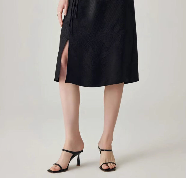 Side view of the skirt with model's right foot forward, showing slit and structure. From Borcelleclothes.