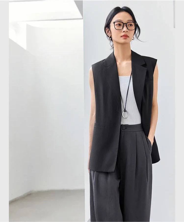 Woman in Onyx Sleeveless Blazer with hand in pants pocket. From Borcelleclothes.