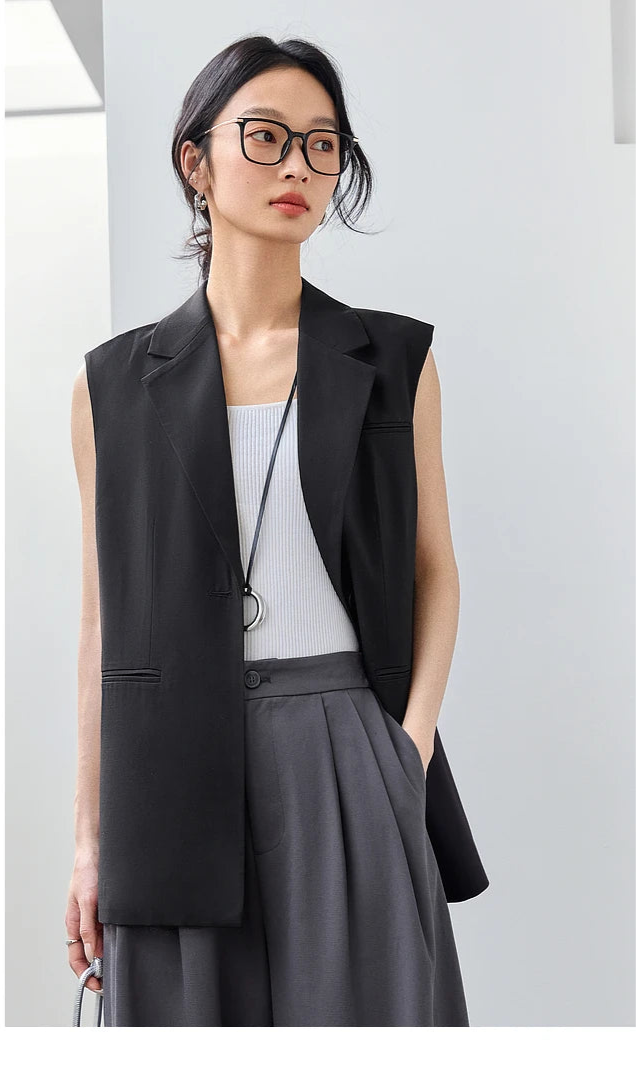 Woman in Onyx Sleeveless Blazer looking to the side. From Borcelleclothes.