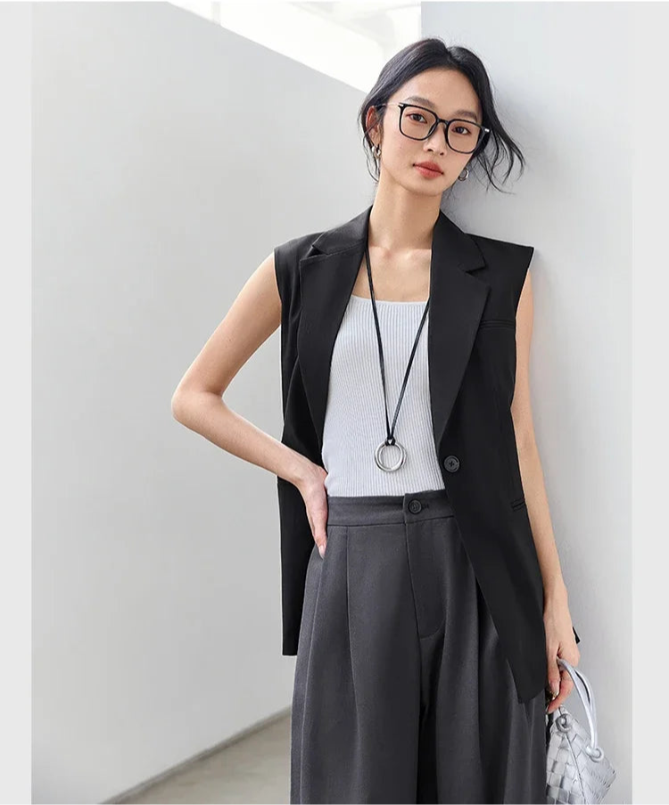 Woman in Onyx Sleeveless Blazer resting one hand on her waist. From Borcelleclothes.