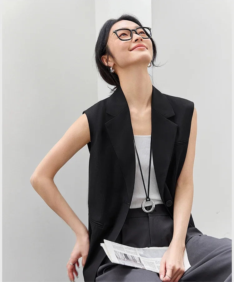 Woman in Onyx Sleeveless Blazer sitting on a chair. From Borcelleclothes.