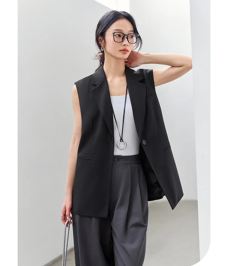 Woman in Onyx Sleeveless Blazer touching her neck. From Borcelleclothes.