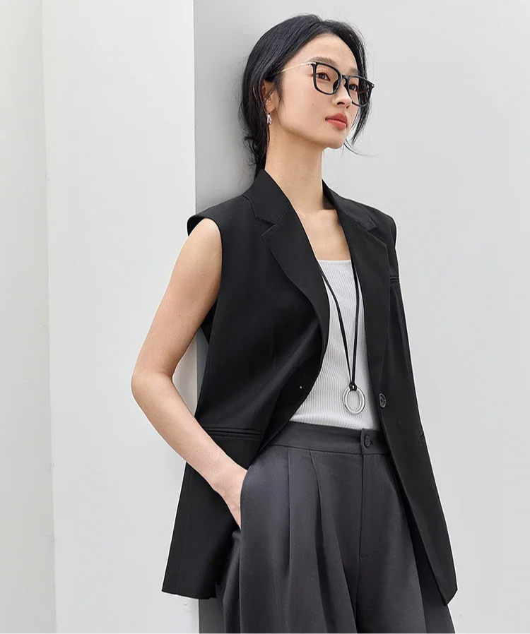 Women’s Onyx Sleeveless Blazer with thigh-length cut, notch lapels, and single tonal button, defined by bold minimalism. From Borcelleclothes.