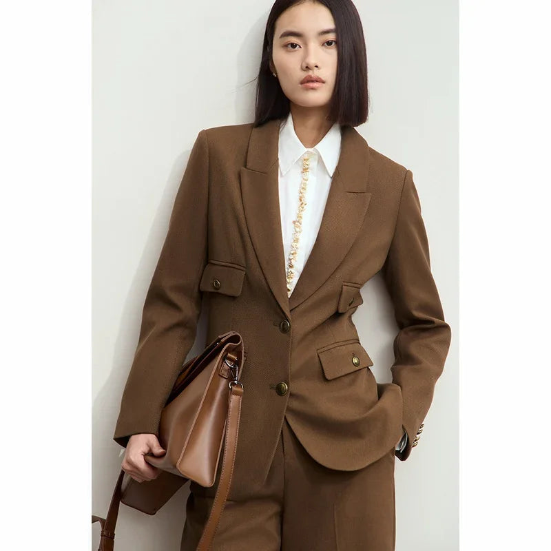 Women’s peaked-lapel blazer in Irish Coffee — a single-breasted design with pointed lapels and convex brass buttons, crafted in a deep, composed shade that absorbs attention with quiet strength. From Borcelleclothes.