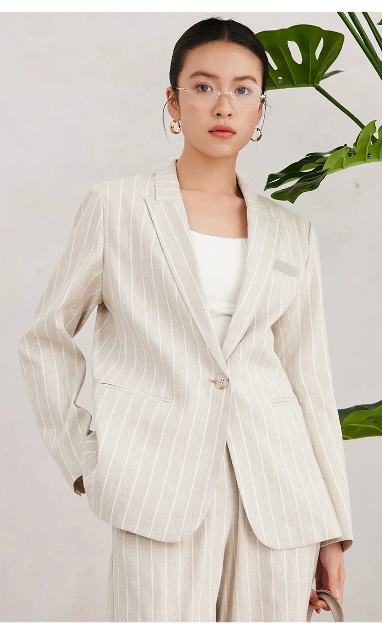 Model wearing Pearl Bush striped blazer with one hand behind the back, highlighting the clean tailoring and relaxed silhouette. From Borcelleclothes.
