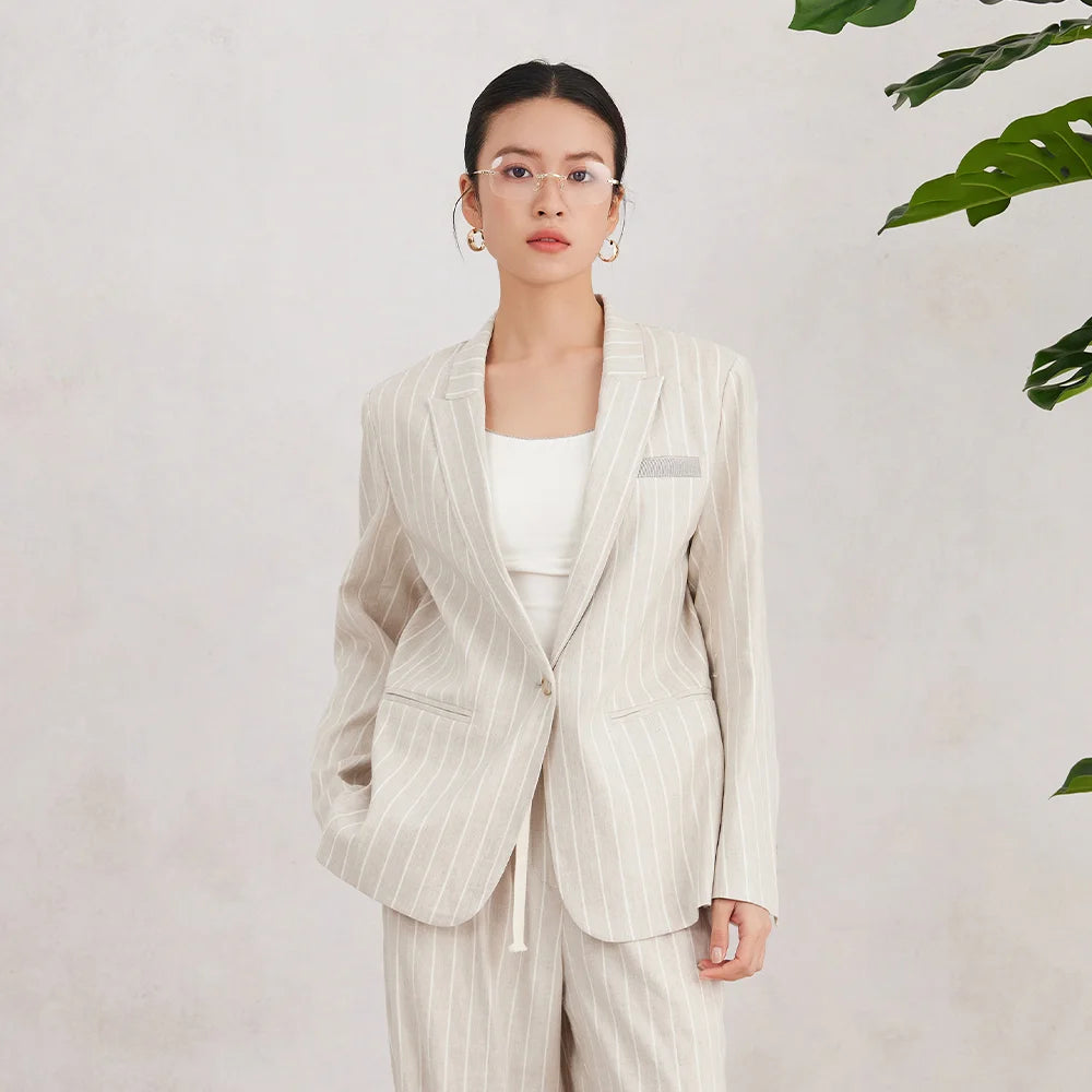 Model wearing Pearl Bush striped blazer, facing forward with composed expression, showing structure and soft color palette. From Borcelleclothes.