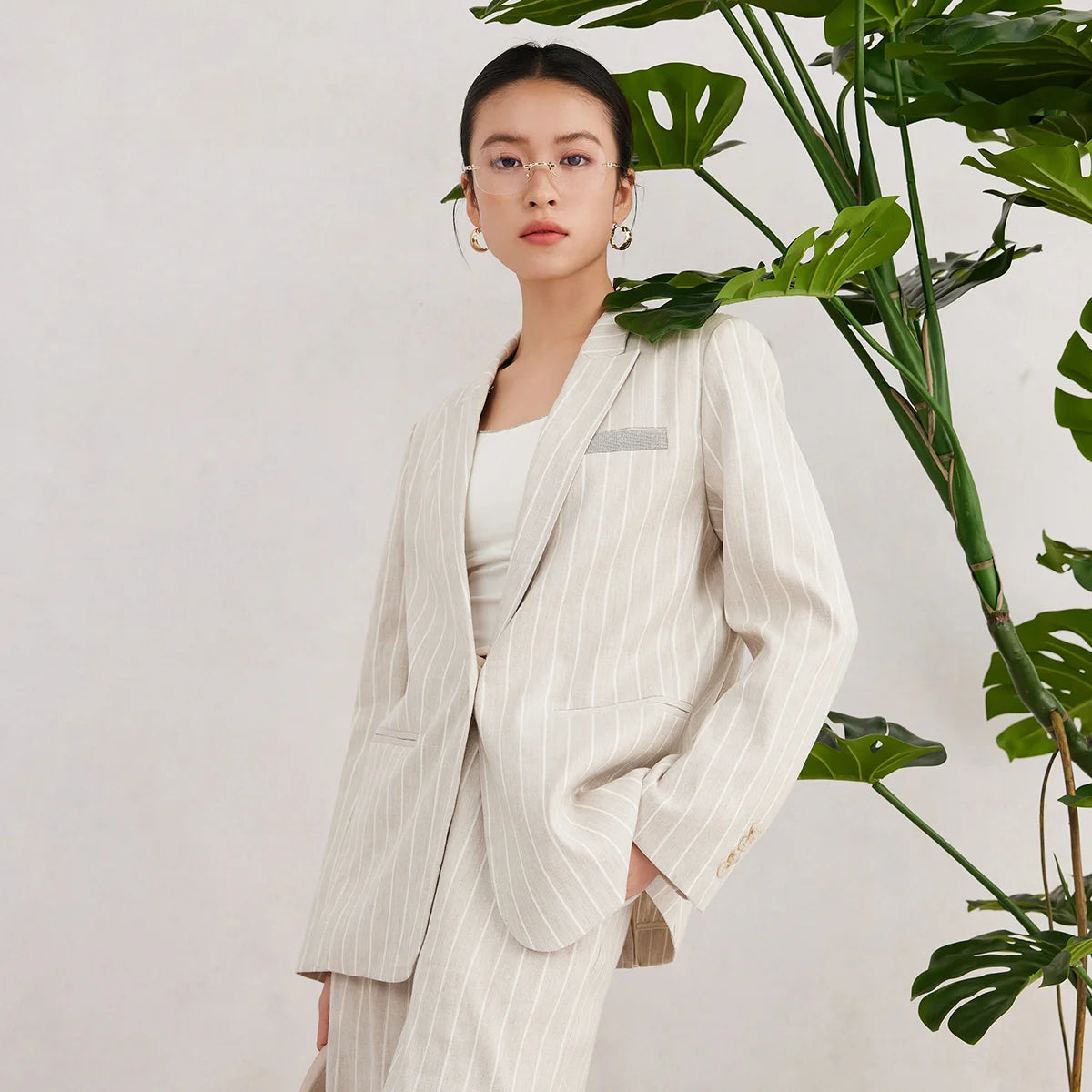 Women’s striped Pearl Bush blazer with peaked lapels, rhinestone-trimmed welt pocket, and soft-toned tailoring. From Borcelleclothes.