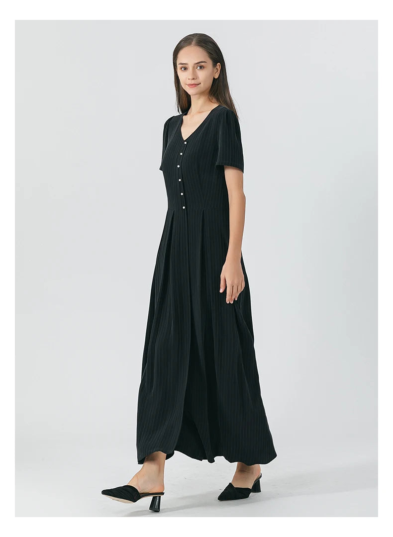 Model walks sideways in the Jaguar silk wrap dress, with the skirt’s volume and pleats in gentle motion. From Borcelleclothes.