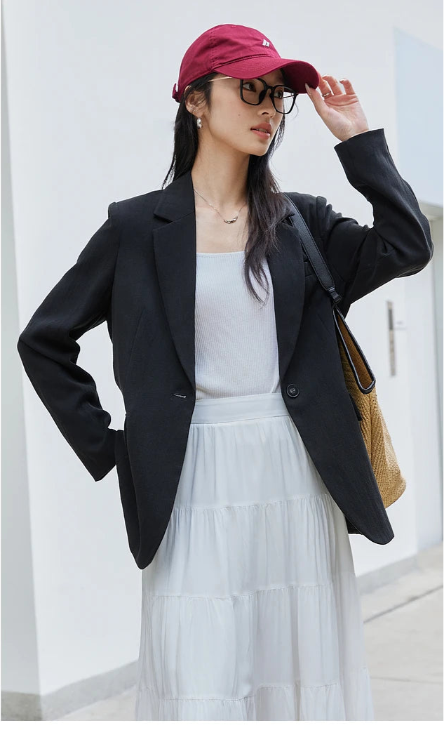 Woman in Onyx Urban Blazer adjusting her cap. From Borcelleclothes.
