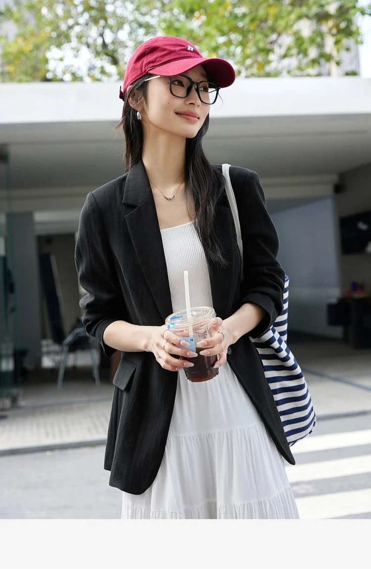 Woman in Onyx Urban Blazer holding a cup of coffee. From Borcelleclothes.