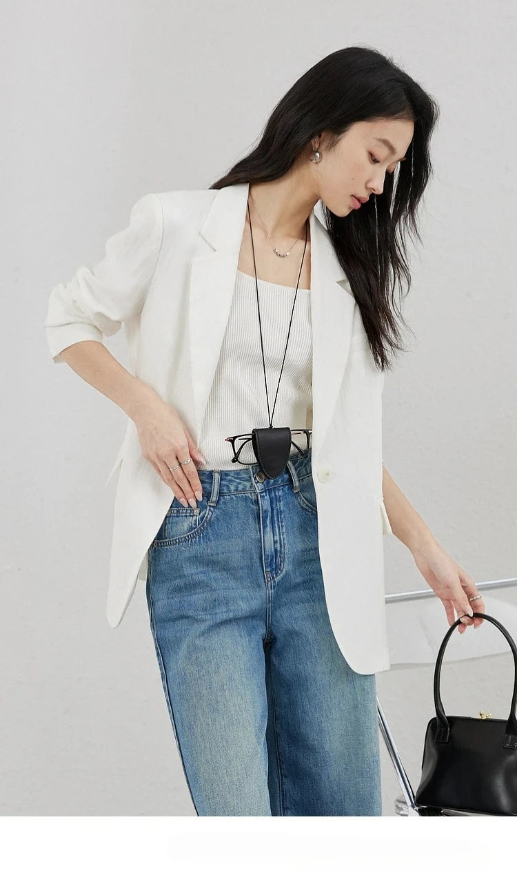 Woman in Platinum Urban Blazer bending forward toward a bag. From Borcelleclothes.