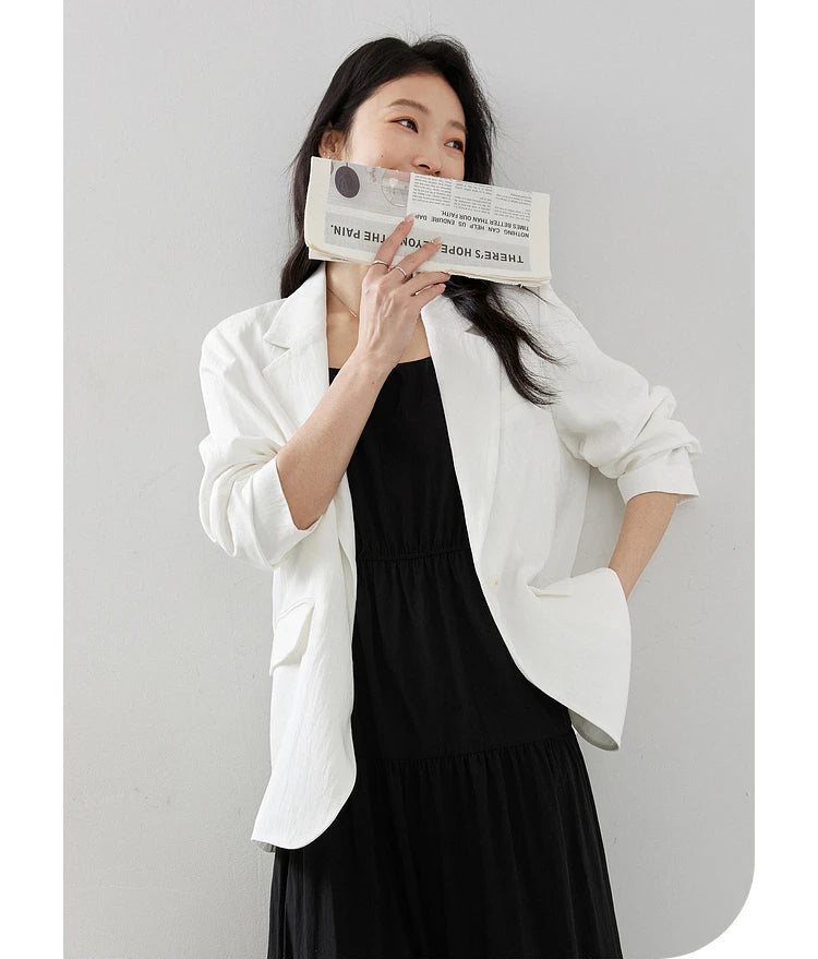 Woman in Platinum Urban Blazer covering lips with a newspaper. From Borcelleclothes.