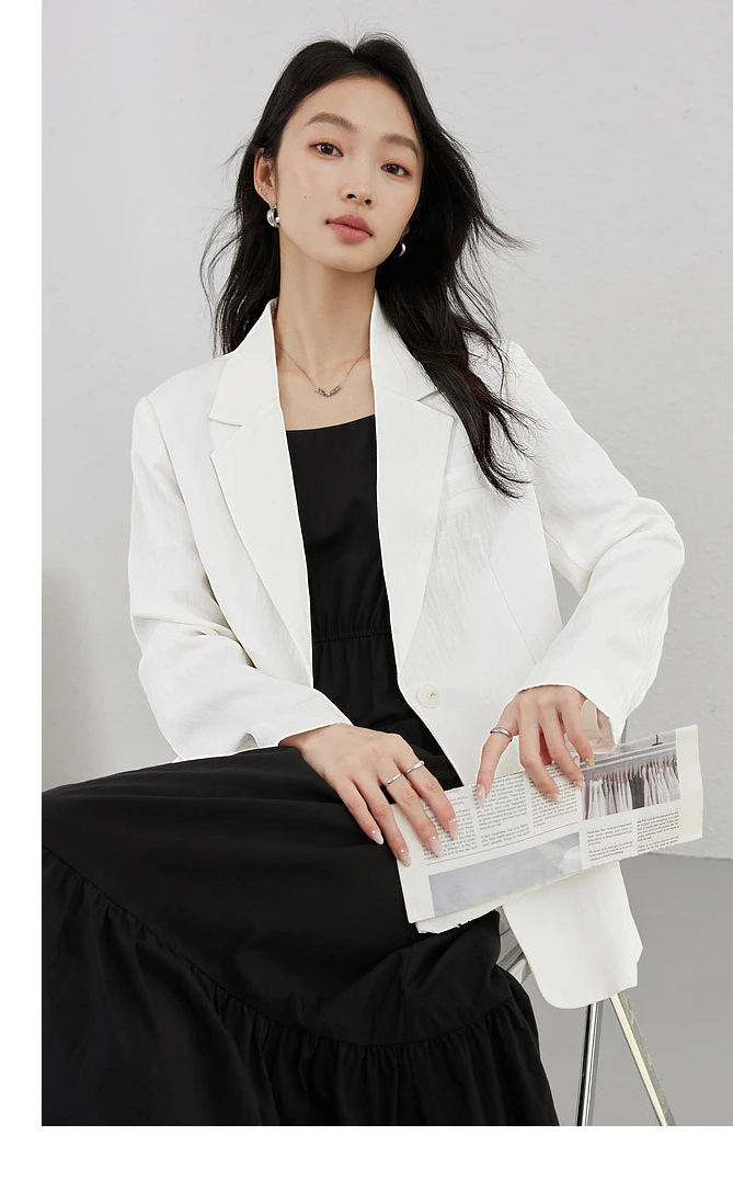 Woman in Platinum Urban Blazer sitting and holding a newspaper. From Borcelleclothes.