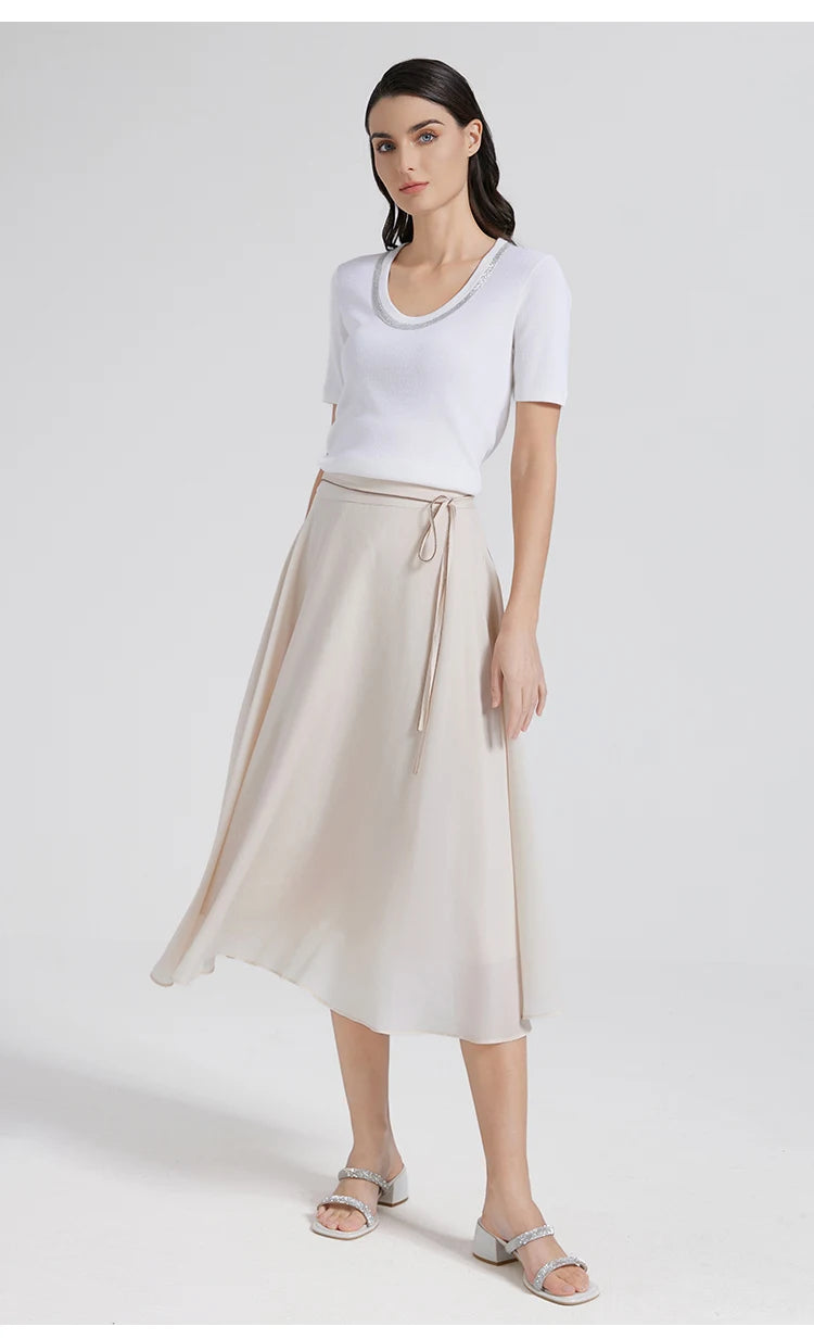 A woman in a slim Merino wool and silk top put her foot on the side. From Borcelleclothes.