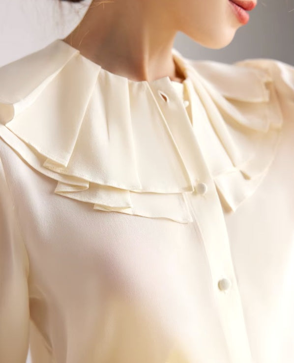 Detailed stitching and textured fabric on the collar of a Women's Romantic Pearl Bush Blouse crafted from 6A Grade Mulberry Silk, featuring a double-layered pilgrim collar with pleats and flounce cuffs for a vintage-inspired, luxurious look. From Borcelleclothes.