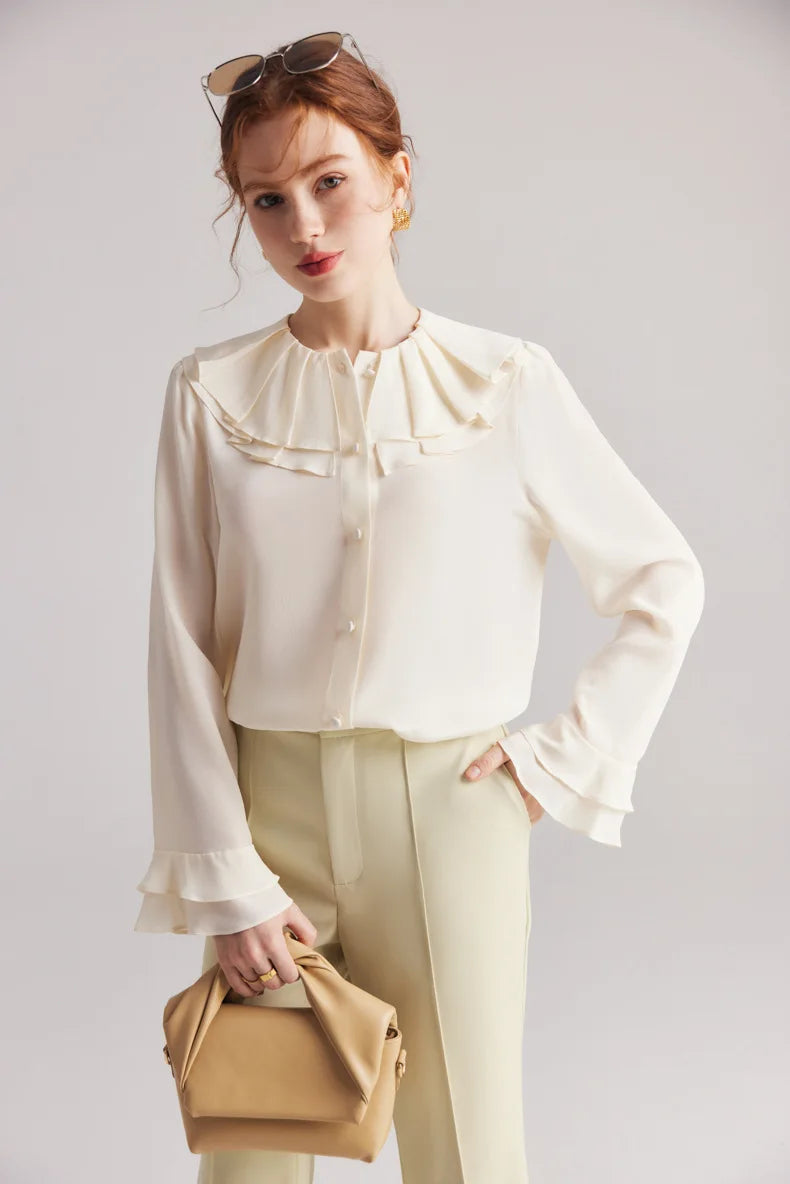 Model in the Women's Romantic Pearl Bush Silk Blouse holds a bag, highlighting the elegant drape and double-layered flounce cuff. From Borcelleclothes.