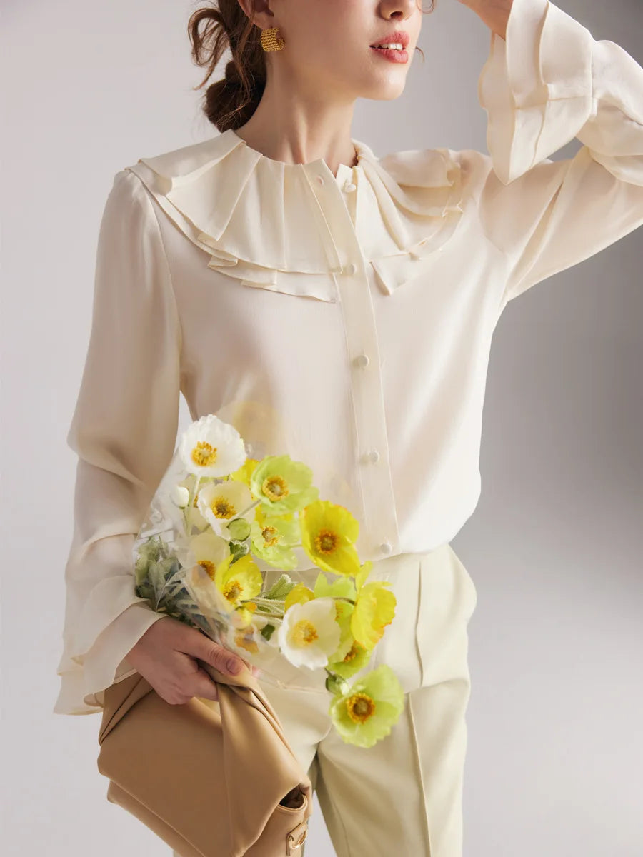 Model in the Women's Romantic Pearl Bush Silk Blouse with a raised arm, highlighting the elegant drape and double-layered flounce cuff. From Borcelleclothes.