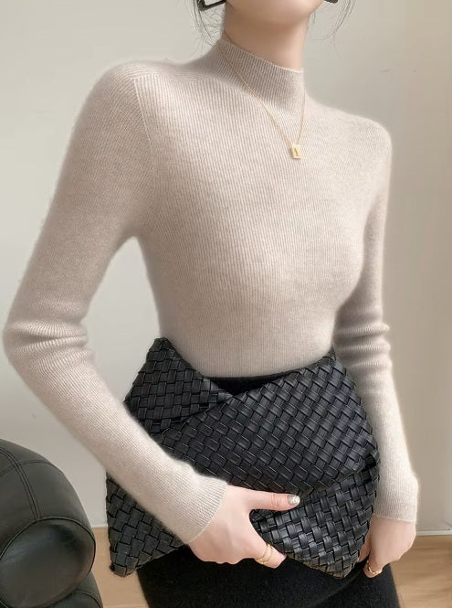 A model wearing the women's Saddle Sleeves Cashmere Sweater in Martini, holding a stylish bag, showcasing the sweater’s elegant fit and structured details, Borcelleclothes.