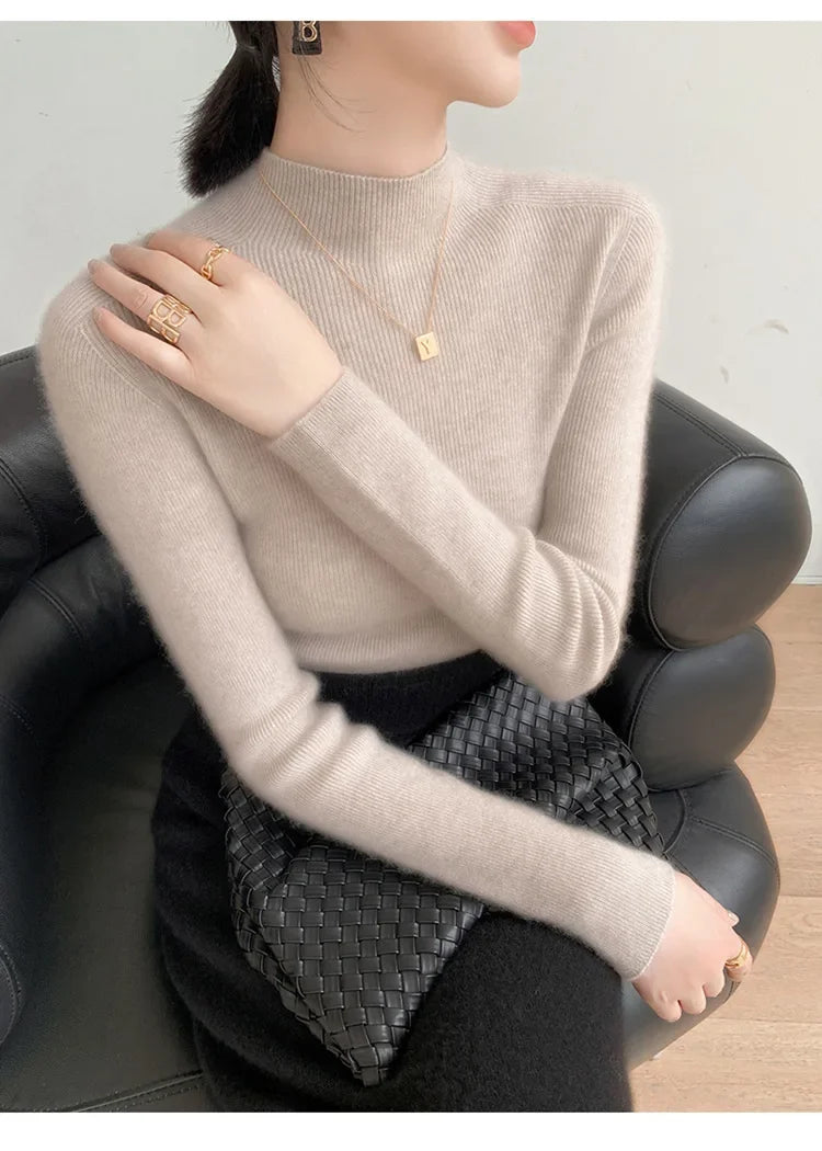 A model wearing the women's Saddle Sleeves Cashmere Sweater in Martini, sitting on the sofa. From Borcelleclothes.