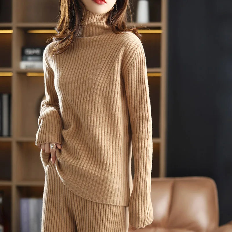 Model wearing the women's Sculpted Wool Set in Light Taupe, showcasing the ribbed texture and pulling up the hem of the top to highlight its relaxed, modern fit, Borcelleclothes.