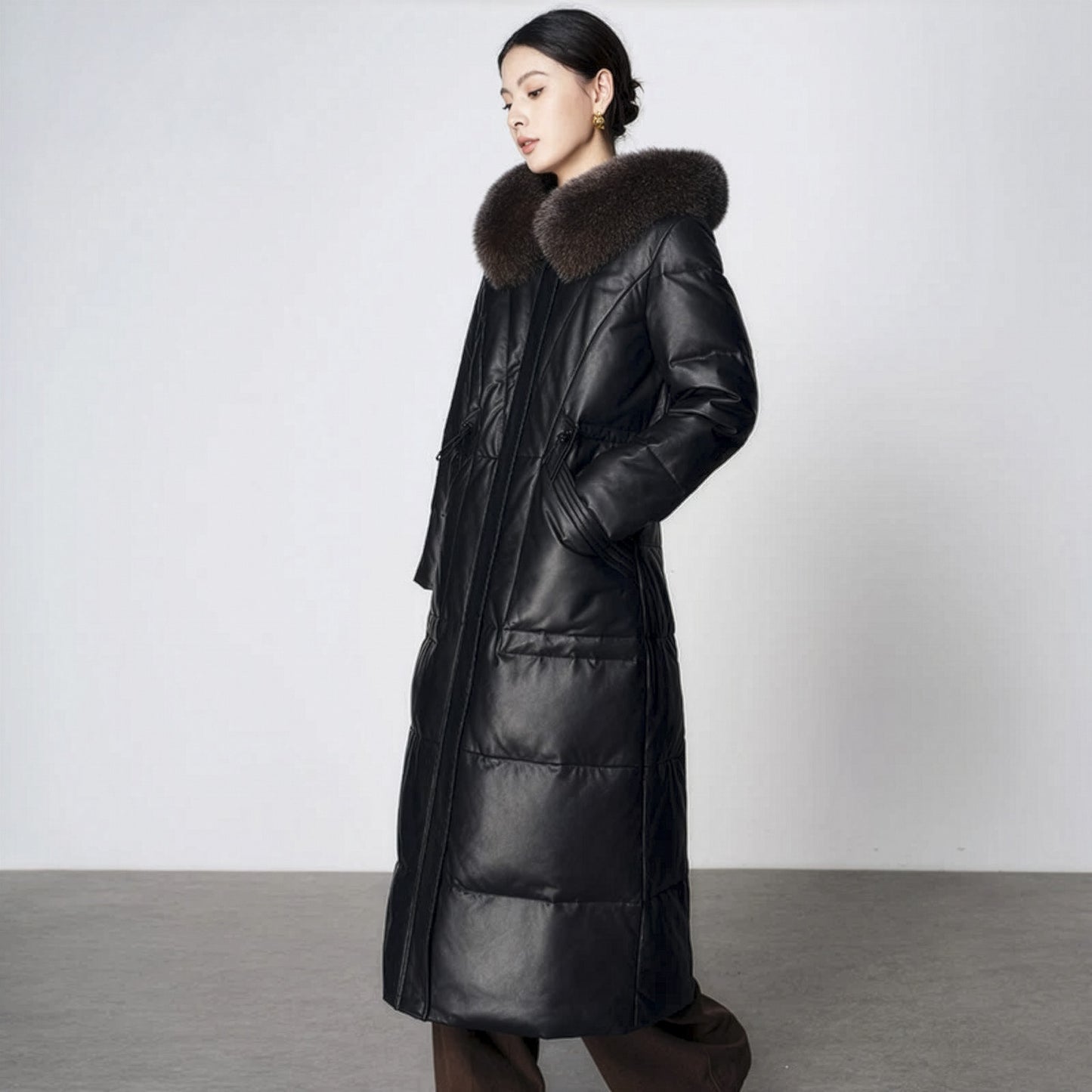 Women's Sheepskin Coat with Hidden Casing in Onyx. Fox-trimmed hood, hidden drawstring waist, goose down fill, mid-calf length. Borcelleclothes.