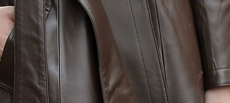 Women's Sheepskin Down Coat in Eclipse. Close-up of the leather texture and pocket area, showcasing the premium sheepskin material. Borcelleclothes.