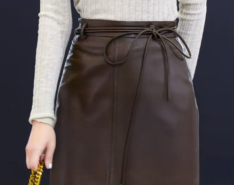 Waist detail of the Dark Rum leather skirt — extended leather tie threaded through loops, offering variation and sculptural presence. From Borcelleclothes.
