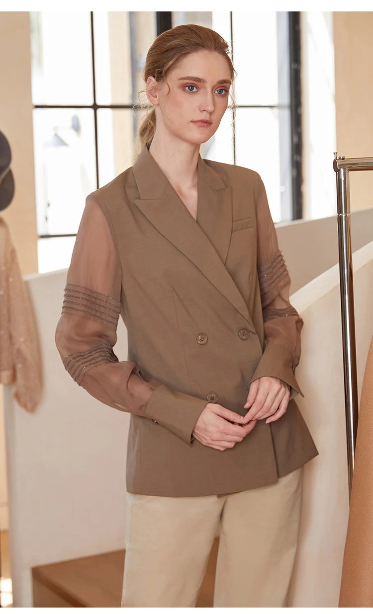 Women’s sheer-sleeved wool blazer in Milk Chocolate, model touching fingers. From Borcelleclothes.