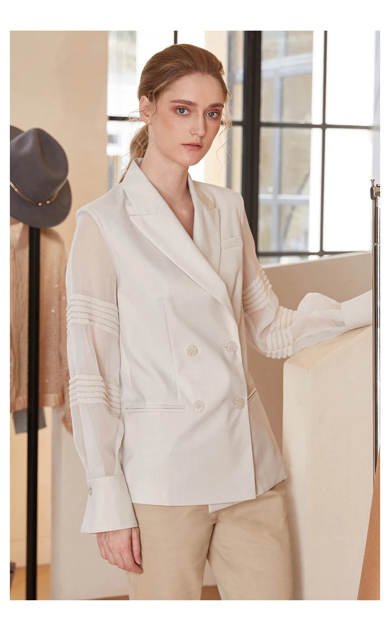 Women’s sheer-sleeved wool blazer in White Coffee, model with arm on white staircase. From Borcelleclothes.