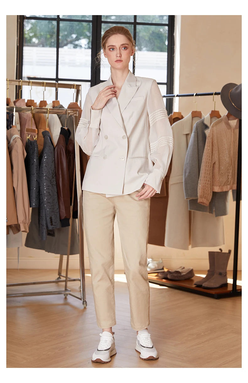 Women’s sheer-sleeved wool blazer in White Coffee, model touching lapel. From Borcelleclothes.