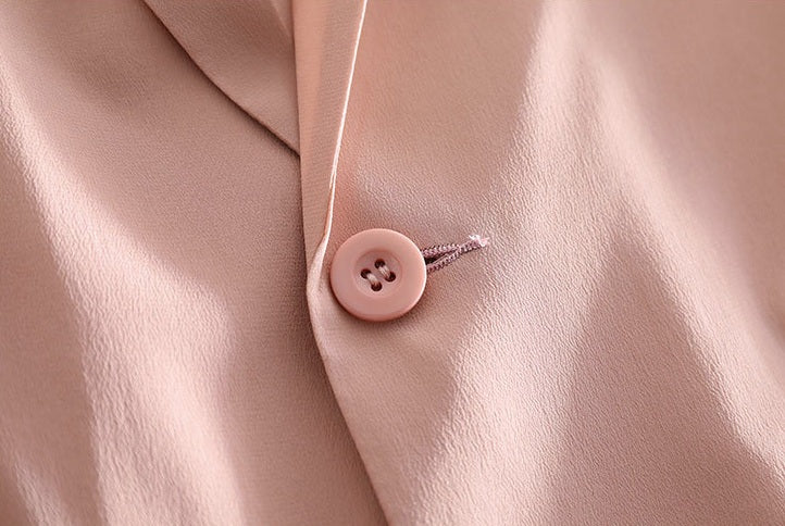 Button detail on the Rose Fog blazer — delicate closure set in soft, whisper-pink silk. From Borcelleclothes.