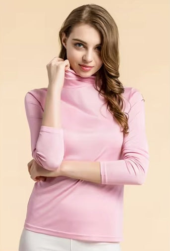 Women's Silk High-Neck Top in Vanilla Ice, crafted from 100% Mulberry Silk for an elegant foundation to showcase jewelry. A model is touching the collar. From Borcelleclothes.
