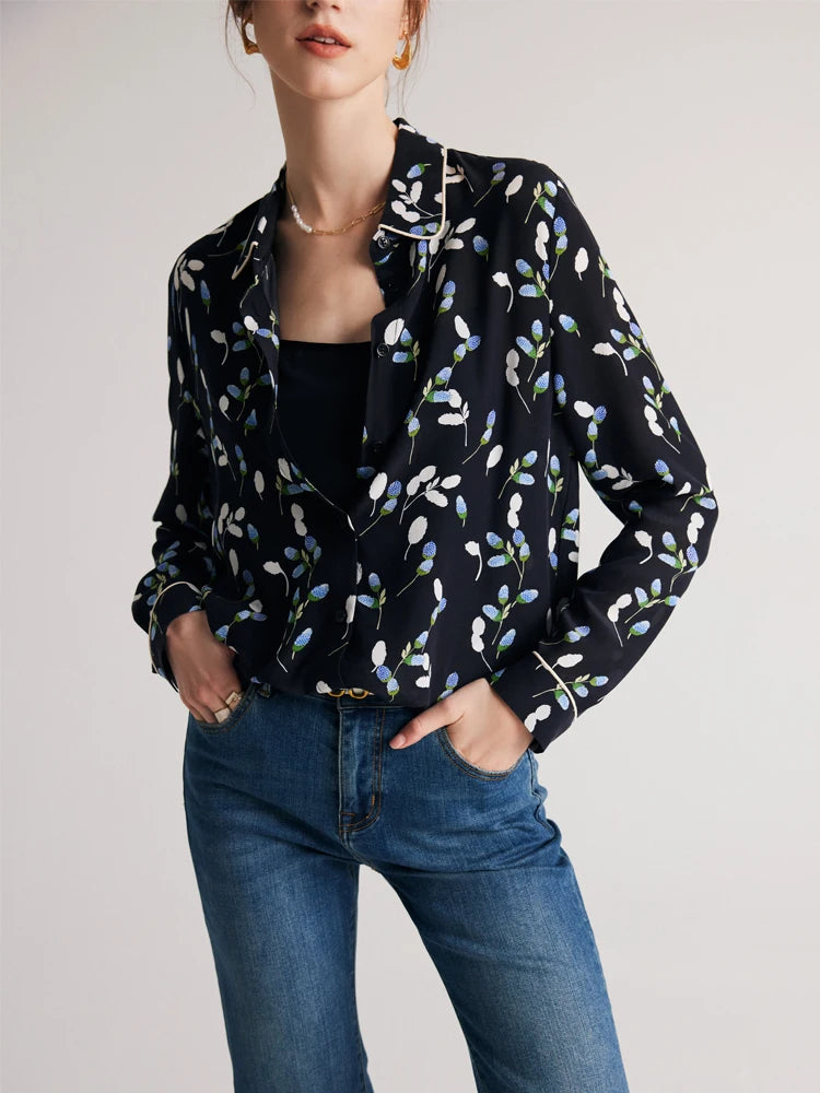Model wearing a women's silk shirt with berry-inspired print, hands in jeans pockets, highlighting a relaxed, chic style. From Borcelleclothes.