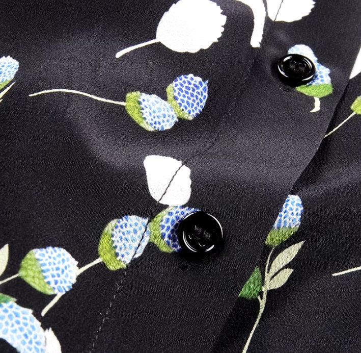 Detailed stitching and textured fabric on the part of the placket with buttons of a women's silk shirt with berry-inspired print. From Borcelleclothes.