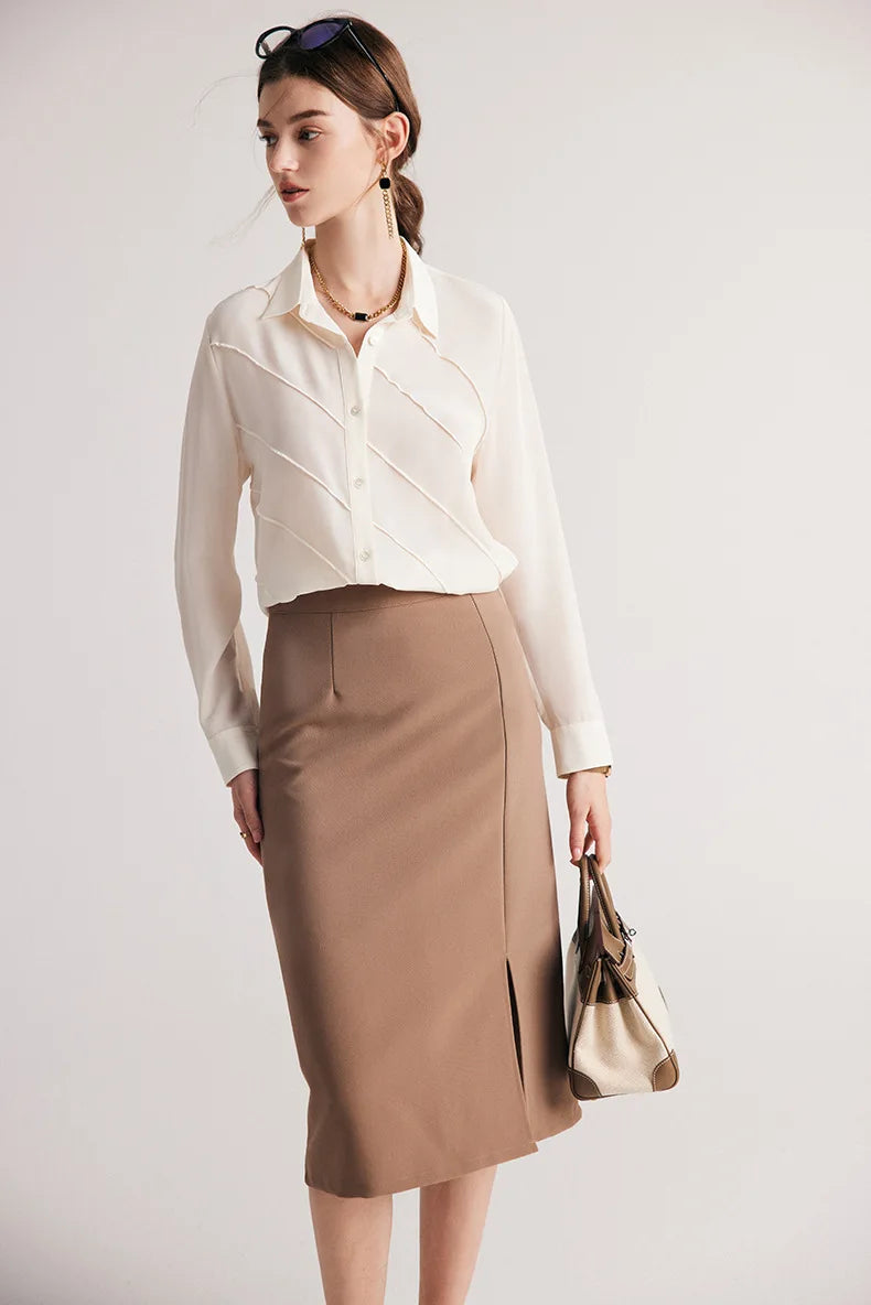 Model holding a bag while wearing silk shirt in Ecru White. From Borcelleclothes.