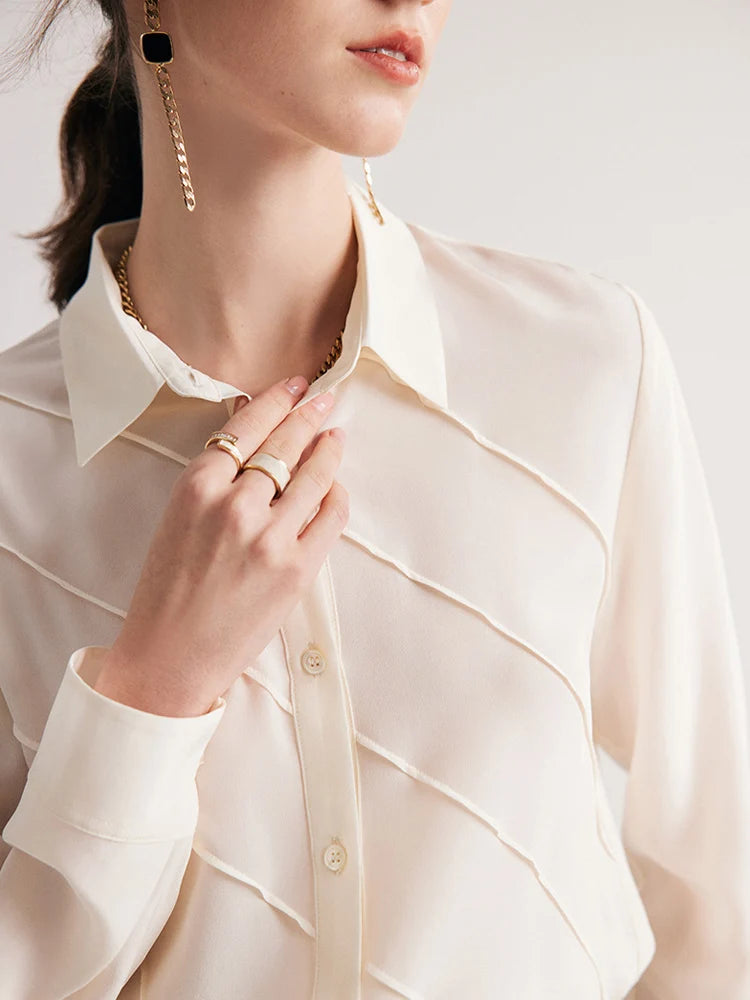 Model touching upper placket of Ecru White silk shirt with diagonal folds. From Borcelleclothes.