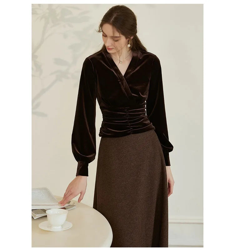 Model wearing Women’s Silk Velvet Blouse in Coffee Bean with sculpted waist, looking thoughtfully at a journal, highlighting the blouse's elegant silhouette and luxurious texture. From Borcelleclothes.