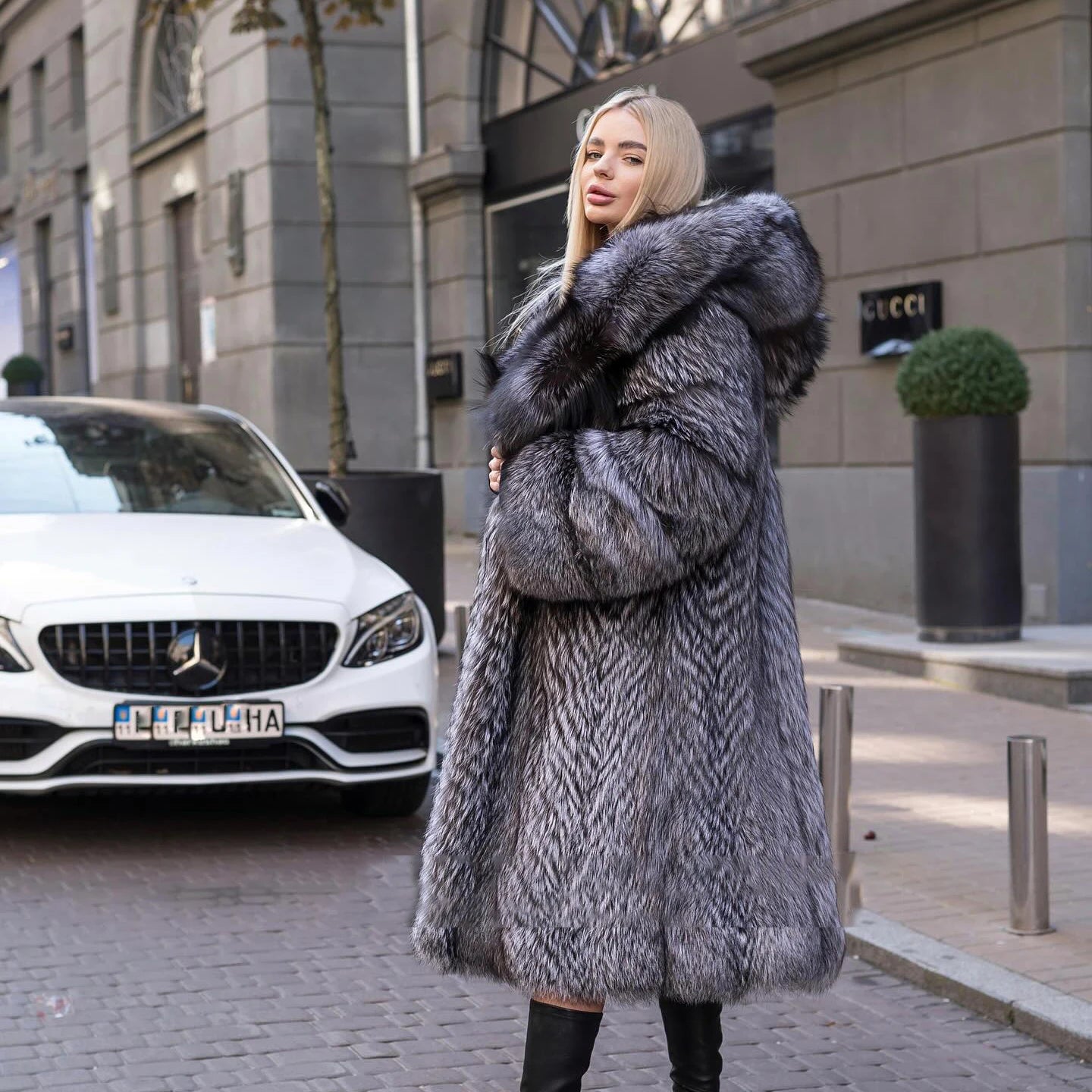 Side profile of a model in a Women's Silver Fox Fur Coat, showcasing the sleek, structured design and flowing fur. From Borcelleclothes.