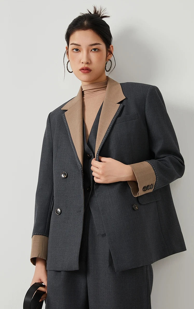 Model wearing women’s Silver Pink & Davy Grey blazer in Davy Grey, touching the front side — From Borcelleclothes.