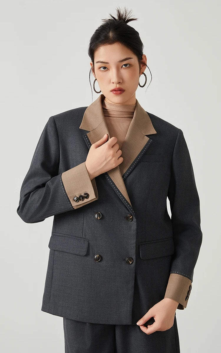 Model wearing women’s Silver Pink & Davy Grey blazer in Davy Grey, touching the lapel — From Borcelleclothes.