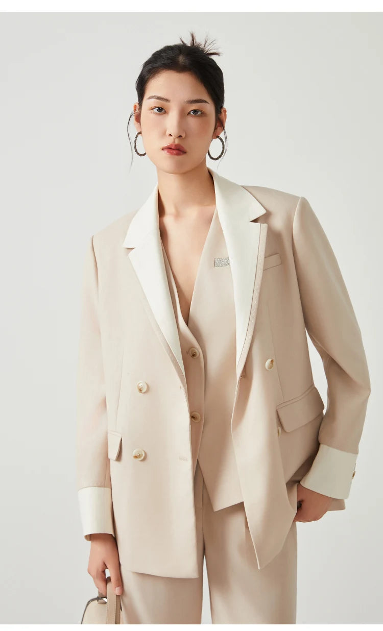 Model wearing women’s Silver Pink & Davy Grey blazer in Silver Pink, touching the bottom hem — From Borcelleclothes.