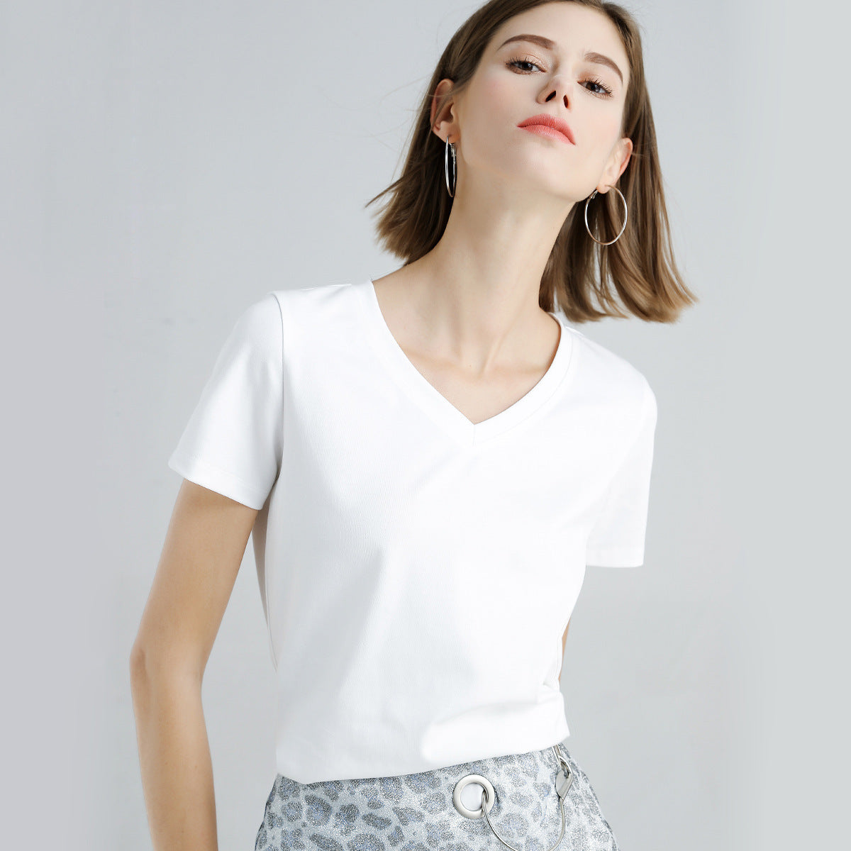 Women's Slim Fit Mercerized Cotton V-Neck T-Shirt in White – Expertly crafted from 100% mercerized cotton, featuring a luxuriously soft and smooth finish. This slim fit T-shirt with a modern V-neck design and sleek, solid pattern is perfect for versatile wear, offering both comfort and a timeless silhouette for any occasion. From Borcelleclothes.