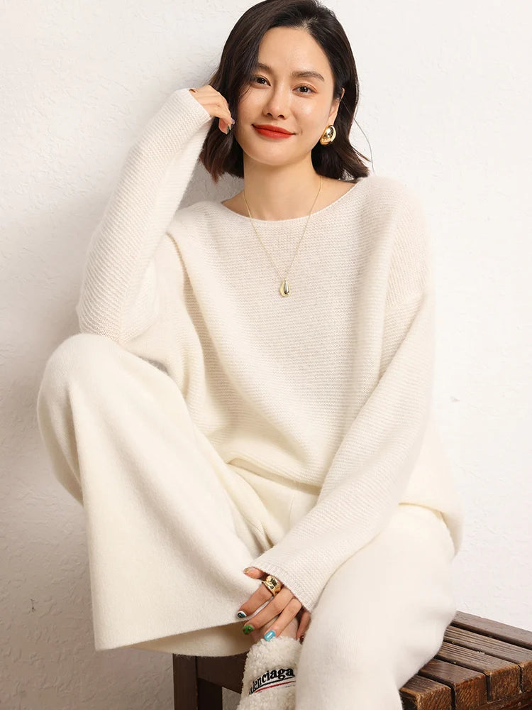 Model sitting on chair in Almond straight-cut cashmere trousers — From Borcelleclothes.