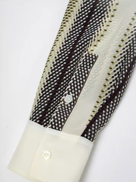 Detailed stitching and textured fabric on the cuff and sleeve's placket of a striped 3D geometric silk shirt with orange, deep blue, and soft yellow stripes, featuring a cream collar and matching cuffs. From Borcelleclothes.