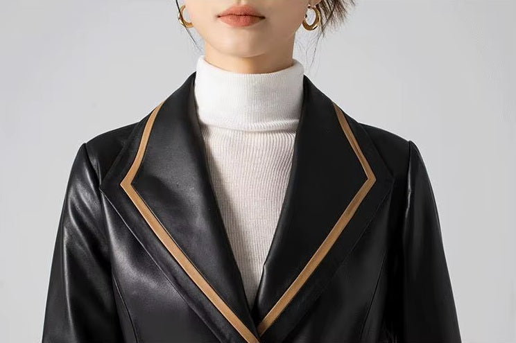 Women's Structured Leather Coat in Onyx with Warm Ochre Trim. Detailed view of the lapel collar, where precise contrast trim enhances sharp tailoring. Borcelleclothes.