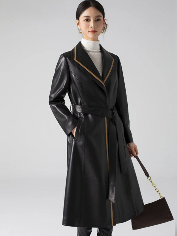 Women's Structured Leather Coat in Onyx with Warm Ochre Trim. Model carries a structured handbag, accentuating the coat’s poised elegance and composure. Borcelleclothes.