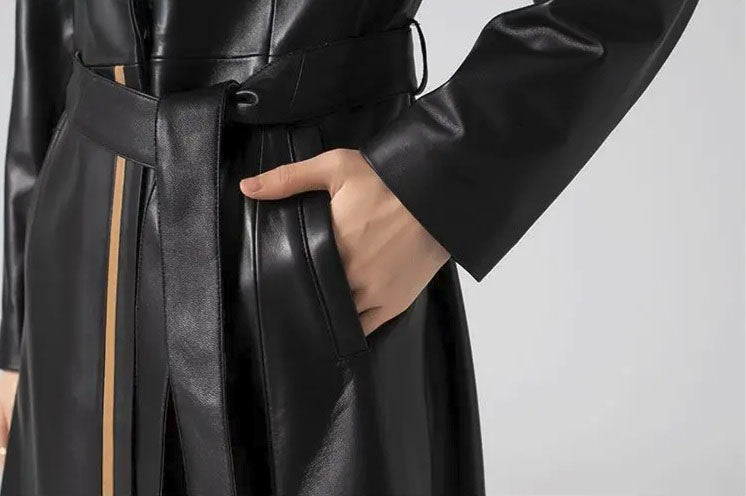Women's Structured Leather Coat in Onyx with Warm Ochre Trim. Model rests a hand in the pocket, emphasizing the coat’s clean structure and refined practicality. Borcelleclothes.